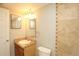 Well-lit bathroom featuring a vanity, toilet, and tiled wall detail at 3100 S Federal Blvd # 307, Denver, CO 80236