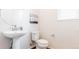 Powder bathroom with modern pedestal sink and toilet with hardwood-style flooring at 17850 W 94Th Dr, Arvada, CO 80007