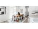 Dining area adjacent to kitchen features wood table, rug, and minimalist decor at 17850 W 94Th Dr, Arvada, CO 80007
