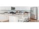 Modern kitchen with stainless steel appliances, a central island with seating, and ample cabinet space at 17850 W 94Th Dr, Arvada, CO 80007