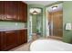 Elegant bathroom featuring a soaking tub, shower, built in cabinets and neutral tile flooring at 5400 Heatherton Ln, Highlands Ranch, CO 80130