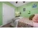 Cozy bedroom with green walls, featuring a floral bedspread and closet with sliding doors at 5400 Heatherton Ln, Highlands Ranch, CO 80130