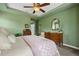 Well-lit bedroom showcasing a comfortable bed, ceiling fan, and a dark wood dresser at 5400 Heatherton Ln, Highlands Ranch, CO 80130