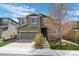 Charming two-story home with stone accents, a manicured lawn, and a two car garage at 5400 Heatherton Ln, Highlands Ranch, CO 80130
