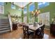 Open-concept living area featuring a dining set, staircase, and cozy seating beneath soaring ceilings at 5400 Heatherton Ln, Highlands Ranch, CO 80130