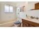 Cozy bathroom featuring a single vanity, tub/shower combo and tiled walls at 798 Xenophon St, Lakewood, CO 80401
