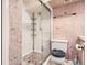 This bathroom features a tile shower with a glass door and a toilet with pink themed wallpaper at 798 Xenophon St, Lakewood, CO 80401