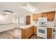 Bright, open kitchen with oak cabinets, white appliances, and a view into the adjacent dining area at 798 Xenophon St, Lakewood, CO 80401