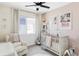 Cozy Bedroom with pastel walls, crib, rocking chair, and a window at 2023 S Upham Way, Denver, CO 80227