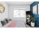 Modern bedroom with a blue accent wall, window, and a minimalist design at 2023 S Upham Way, Denver, CO 80227