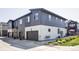 Modern townhome exterior with grey and white siding and attached garages at 2023 S Upham Way, Denver, CO 80227
