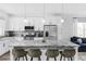 Bright, all-white kitchen featuring a spacious island with granite countertops and modern stainless steel appliances at 2023 S Upham Way, Denver, CO 80227