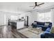 Open floor plan showcasing a modern kitchen island flowing into a comfortably furnished living area with hardwood floors at 2023 S Upham Way, Denver, CO 80227