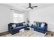 Bright living room showcasing hardwood floors, a light-colored rug, and two blue couches at 2023 S Upham Way, Denver, CO 80227