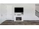 Living room area with a fireplace and mounted television, adjacent to staircase and entry door at 2023 S Upham Way, Denver, CO 80227