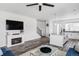 Open concept living room features a fireplace, ceiling fan, and adjoins a kitchen with a granite-topped island at 2023 S Upham Way, Denver, CO 80227