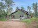 Exterior backyard featuring a patio, seating, wooden swing, and lush green trees at 26765 Bradley St, Conifer, CO 80433