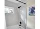 Modern bathroom with gray tiling, white shower and bathtub combo, and black hardware at 26765 Bradley St, Conifer, CO 80433