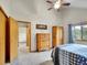 Bedroom showcasing an opened doorway, carpet, ceiling fan, window, and wood furniture at 26765 Bradley St, Conifer, CO 80433