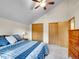 Bedroom featuring blue and white plaid bedding, a ceiling fan, and double door closets at 26765 Bradley St, Conifer, CO 80433