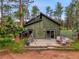 Back of house view with patio, wooden siding, and large sliding glass door to the backyard at 26765 Bradley St, Conifer, CO 80433