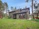 Charming two-story home with wood siding and well-maintained front yard surrounded by mature trees at 26765 Bradley St, Conifer, CO 80433