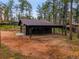 A detached two car garage with an attached covered parking area with a gated entrance at 26765 Bradley St, Conifer, CO 80433