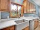 Bright kitchen featuring a farmhouse sink, quartz countertops, and wood cabinets at 26765 Bradley St, Conifer, CO 80433