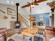 Bright living room features a wood-burning fireplace, open staircase, and adjacent dining area at 26765 Bradley St, Conifer, CO 80433