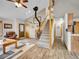Bright living room with wood floors, wooden staircase, fireplace, and leather furniture at 26765 Bradley St, Conifer, CO 80433