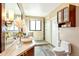 Bathroom with stylish vanity, large mirror, and a glass enclosed shower with a pebble floor at 4730 W Moncrieff Pl, Denver, CO 80212