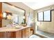 Bathroom with stylish vanity, large mirror, and walk-in shower with a pebbled floor at 4730 W Moncrieff Pl, Denver, CO 80212