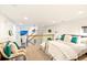 Cozy mezzanine bedroom with comfortable bed, leather couch, and bright natural light at 4730 W Moncrieff Pl, Denver, CO 80212