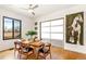 Bright dining room with wood floors, a garage door window, a ceiling fan, and a large art piece at 4730 W Moncrieff Pl, Denver, CO 80212