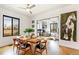 Bright dining room flows to office with garage door window, wood floors, and large modern art piece at 4730 W Moncrieff Pl, Denver, CO 80212