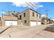 View of the home's rear three-car garage with upper balconies and rooftop terrace at 4730 W Moncrieff Pl, Denver, CO 80212