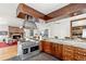 Spacious living room with wood floors, fireplace, exposed beams and open access to kitchen at 4730 W Moncrieff Pl, Denver, CO 80212