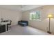 Bright bedroom with a desk, couch, and a large window offering natural light, ideal for work or relaxation at 10295 Ravenswood Ln, Highlands Ranch, CO 80130