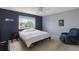 Comfortable bedroom with dark accent wall, and inviting natural light from large window at 10295 Ravenswood Ln, Highlands Ranch, CO 80130