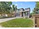 Two-story home featuring a front yard with lush green grass, mature trees, and a two-car garage at 10295 Ravenswood Ln, Highlands Ranch, CO 80130