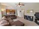 Spacious living room featuring an open floor plan, ceiling fan, and inviting brown sectional sofa at 10295 Ravenswood Ln, Highlands Ranch, CO 80130