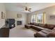 Comfortable living room with a fireplace, a ceiling fan, and large windows for natural light at 10295 Ravenswood Ln, Highlands Ranch, CO 80130