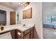Bathroom with a single sink vanity, wood cabinets, and a large mirror at 1325 S Idalia St, Aurora, CO 80017