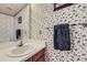 Half bath features a single sink vanity, mirror and decorative wallpaper at 1325 S Idalia St, Aurora, CO 80017