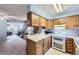 Efficient kitchen layout with wood cabinets, double oven, and seamless flow to the living spaces at 1325 S Idalia St, Aurora, CO 80017