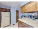 Traditional kitchen featuring wood cabinetry, light blue walls, and a view into the adjacent dining area at 1325 S Idalia St, Aurora, CO 80017