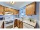 Cozy kitchen with white appliances, wood cabinets, and a window with natural light at 1325 S Idalia St, Aurora, CO 80017