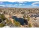 Breathtaking aerial view of a community pond, playground, and lush green spaces with mountain views in the background at 6616 Zinnia St, Arvada, CO 80004