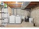 Functional basement laundry area with a washer, dryer, sink, and shelving for storage at 6616 Zinnia St, Arvada, CO 80004