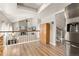 Open concept design of the living room and kitchen with stainless steel refrigerator at 6616 Zinnia St, Arvada, CO 80004